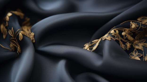 A close up of a black and gold fabric with some leaves