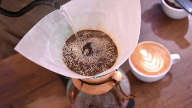 Barista pours water into the filter with coffee, brewing coffee. Alternative coffee-making methods