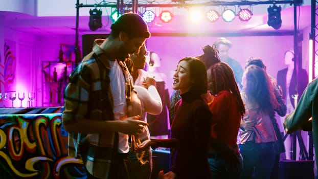 Happy couples partying at nightclub, enjoying romantic music and dancing in pairs. Dance partners waltzing and having fun with people at celebration event, attending disco party. Handheld shot.