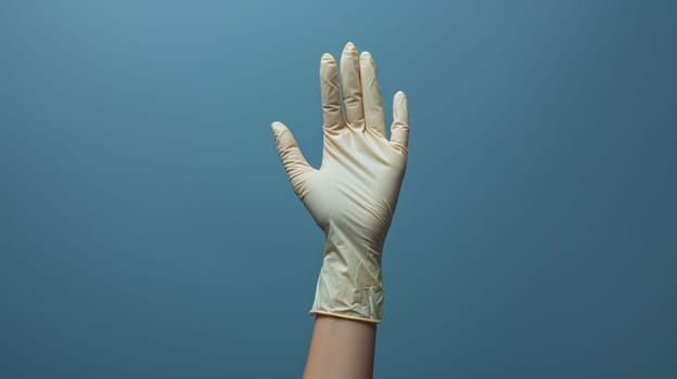 A person wearing a latex glove on their hand against blue background