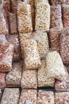 many mixed nuts in a plastic packet on shelf . High quality photo