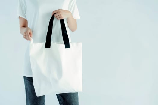 woman Hand holding a White Polyester square tote bag for mockup . AI generated image.