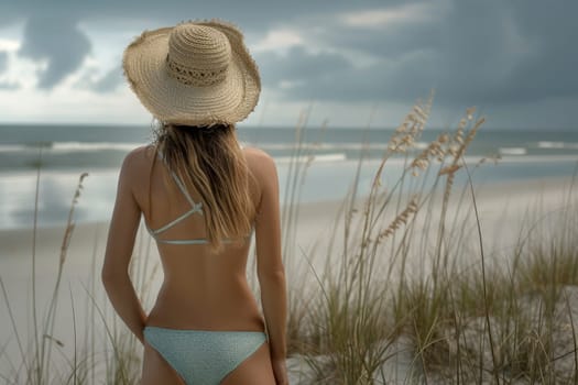 A woman in a hat is on the beach . summer vacation concept. nice weather, blue sky. Generative AI.