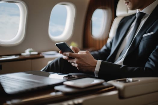 Working on airplane, businessman sitting and using smartphone inside airplane near the window.