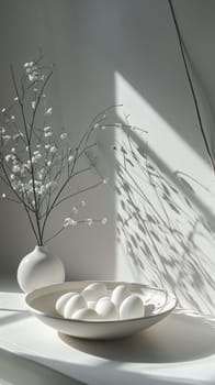 A white bowl with eggs and a branch of flowers on the table