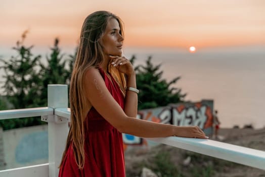 Woman sunset sea red dress, portrait happy beautiful sensual woman in a red long dress posing above the sea on sunset