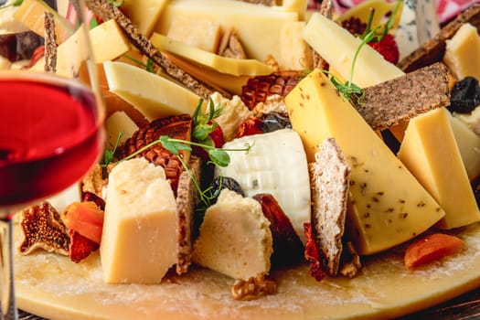 Cheese plate prepared with luxury cheeses and wine on wooden table