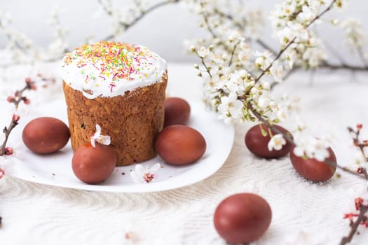 Easter background with colored eggs, colored easter eggs and blooming branches. Easter composition. Easter cake.