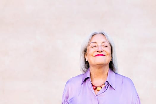 portrait of a nice senior woman smiling with eyes closed, elderly people happiness and active lifestyle concept, copy space for text