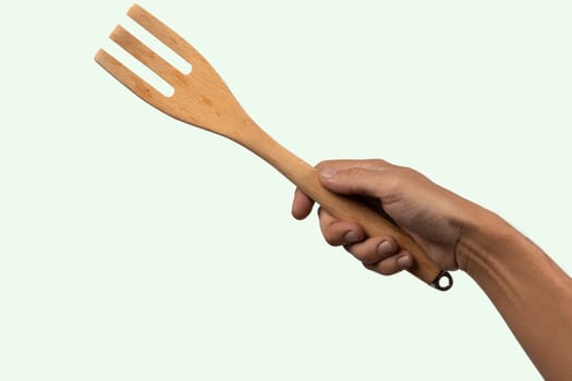 Hand holding wooden fork no background cutout. High quality photo