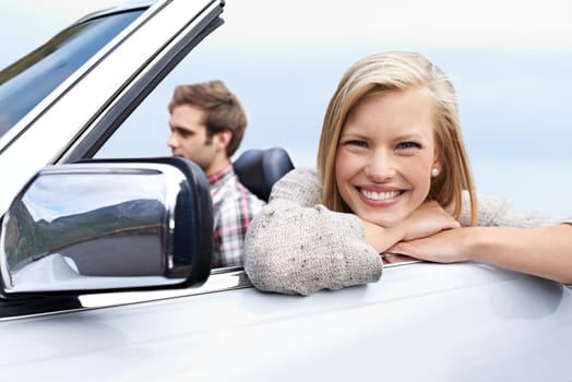 Woman, portrait and man driving convertible for travel adventure for vacation, road trip or holiday. Couple, relax and transportation with smile in California for weekend journey, together or bonding.