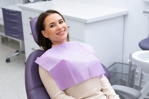 Young beautiful woman sitting in a dental chair waiting for the doctor in a dental clinic.
