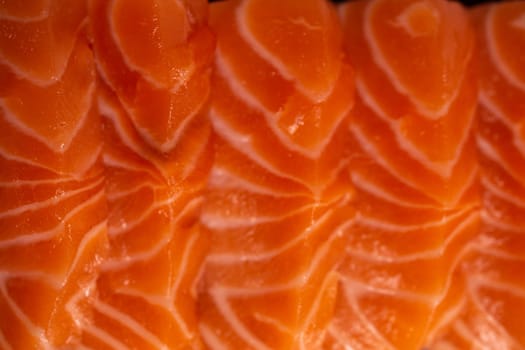 Close-up of fresh raw salmon fillet. Isolated on white background. Salmon is a type of fish that is often used in sushi and sashimi. It has a delicate flavor and a slightly pink color.