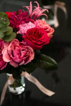 Vivid bouquet of pink and red roses in a glass vase against a black backdrop. Perfect for special occasions like Valentines Day or Mothers Day, this striking floral display is a heartfelt gift.