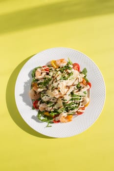 Delicious and healthy salad with greens, cherry tomatoes, and grilled shrimps. Served on a white plate, the image features a clean, modern look. Perfect for stock agencies or as a mockup.