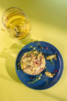 Seafood salad with succulent shrimp, crab, avocado, and light mayo on a blue plate. Served with white wine on a yellow background. Perfect for a light and satisfying meal.