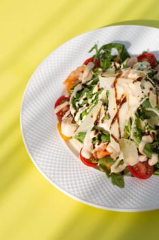 Delicious and healthy salad with greens, cherry tomatoes, and grilled shrimps. Served on a white plate, the image features a clean, modern look. Perfect for stock agencies or as a mockup.