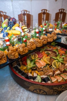 An opulent buffet showcasing a lavish assortment of fresh seafood, sushi, salads, fruits, and pastries, beautifully arranged on a pristine white tablecloth for a luxurious and celebratory event.