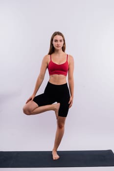 Beautiful female in yoga studio. A woman doing yoga. Lady in a top.