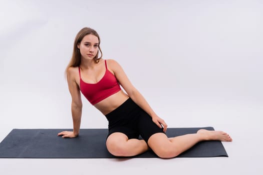 Beautiful female in yoga studio. A woman doing yoga. Lady in a top.