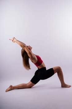 Beautiful female in yoga studio. A woman doing yoga. Lady in a top.