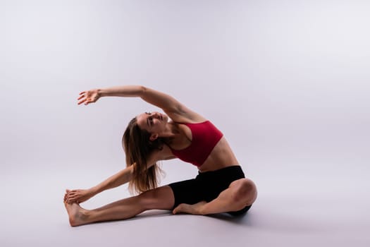 Beautiful female in yoga studio. A woman doing yoga. Lady in a top.