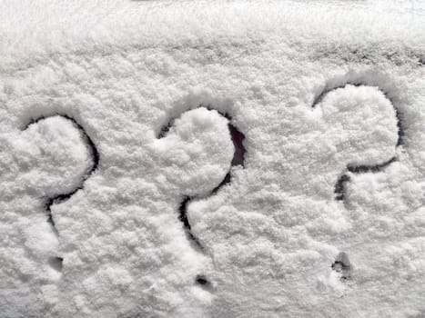 Three question marks written in snow. The cold frosty texture of the snow and the question mark. Background, place for text, copy space