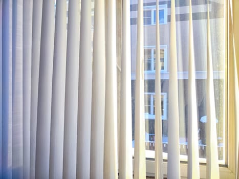 View of a window adorned with clean white curtains window blind against a simple backdrop. Background, texture, pattern, frame, copy space