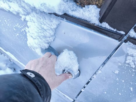 Frozen Car Lock on a Cold Winter Day. Woman person attempts to unlock frozen car door. Problem during trip and travel in the cold winter months