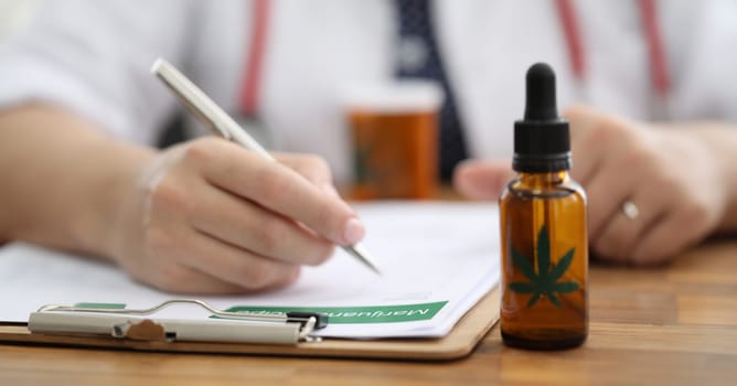 Closeup doctors hand writing prescription for hemp. Doctors prescribe cannabis for sleep disturbance. Hemp is part medication recommended for muscle spasms and epilepsy. Brain functioning