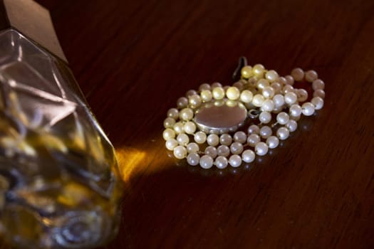 pearl necklace next to a precious stone with light reflections