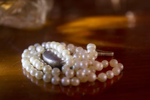 pearl necklace with light reflection on a wooden table
