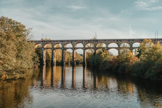 Railway Bridge with river in Bietigheim-Bissingen, Germany. Autumn. Railway viaduct over the Enz River, built in 1853 by Karl von Etzel on a sunny summer day. Bietigheim-Bissingen, Germany. Old viaduct in Bietigheim reflected in the river. Baden-Wurttemberg, Germany. Train passing a train bridge on a cloudy day in Germany