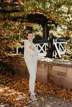 Beautiful elegant woman standing in a park in autumn. autumn yellow leaves. Portrait of joyful woman in park during fall. Happy girl with yellow leaves outdoor. Beauty Romantic Girl Outdoors enjoying nature. Beautiful autumn model with waving glow hair.Sun light on sunset.Warm toned art work. Portrait of romantic female