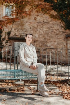 Attractive young woman sitting on a bench enjoying a view of medieval town in Europe. Summer holidays concept.