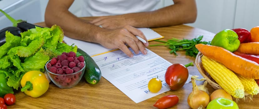 A nutritionist writes a nutrition plan. Selective focus. Food.