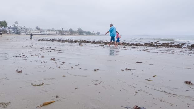 Walking along the shore of Miramar Beach, California, the overcast winter sky creates a tranquil and reflective atmosphere.