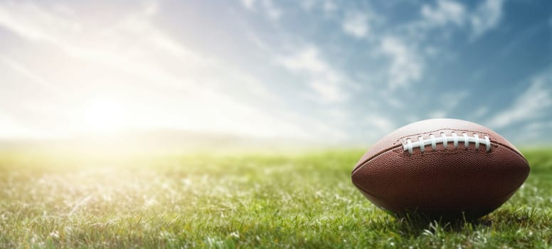 An American football placed on a green grass field with a bright and sunny sky in the background, symbolizing sports and outdoor activities.