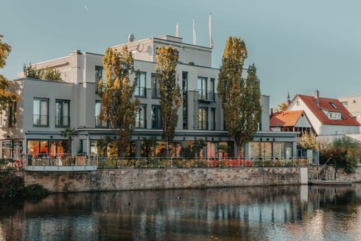 River on sunset. Townhouses buildings and multi-floor home at waterfront. Sunset on River in city. Suburb houses and residential building near river in Europe. House in nature on shore on sunset.