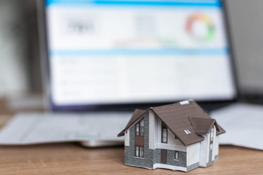 Model house in front of computer with financing plan - mortgaging or home financing concept. High quality photo