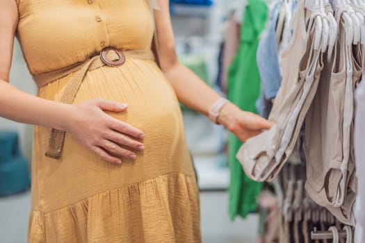 Expectant mother joyfully selects adorable clothes for her unborn baby while enjoying a shopping spree in the vibrant aisles of the shopping center.