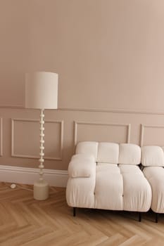 a light beige sofa and a table lamp as part of the interior. High quality photo