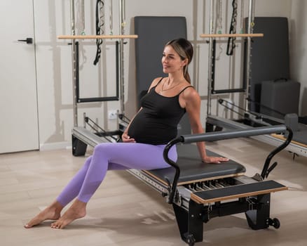 Pregnant woman resting after Pilates on a reformer machine