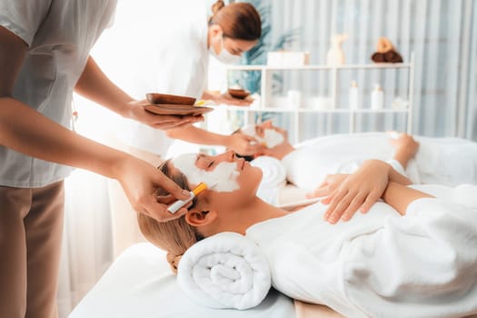 Serene ambiance of spa salon, couple indulges in rejuvenating with luxurious face cream massage with modern daylight. Facial skin treatment and beauty care concept. Quiescent