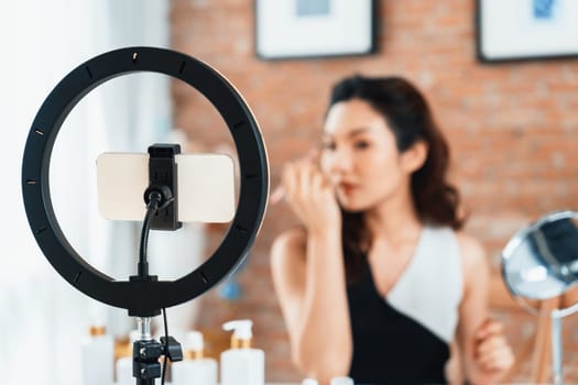 Woman influencer shoot live streaming vlog video review makeup uttermost social media or blog. Happy young girl with cosmetics studio lighting for marketing recording session broadcasting online.