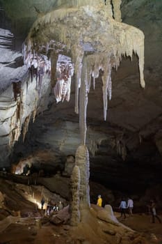 Explorers discover a vast cave filled with striking stalactites and stalagmites.