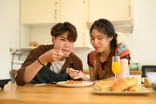 Romantic couple enjoying lunch in the kitchen. Love, relationships and food concept