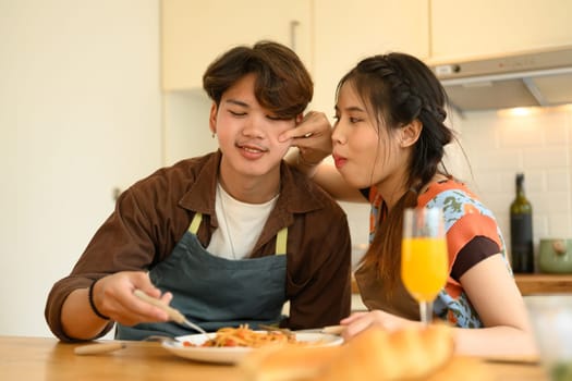 Loving young couple having romantic dinner together at home. People, relationships and food concept.