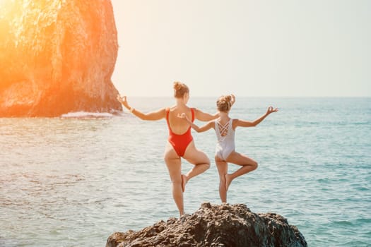 Silhouette mother and daughter doing yoga at beach. Woman on yoga mat in beach meditation, mental health training or mind wellness by ocean, sea