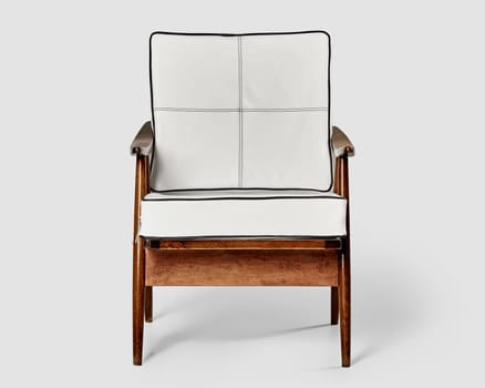 Vintage style chair with white leather cushions and curved wooden arms, presenting fusion of comfort and stylish design. Artisanal furniture concept